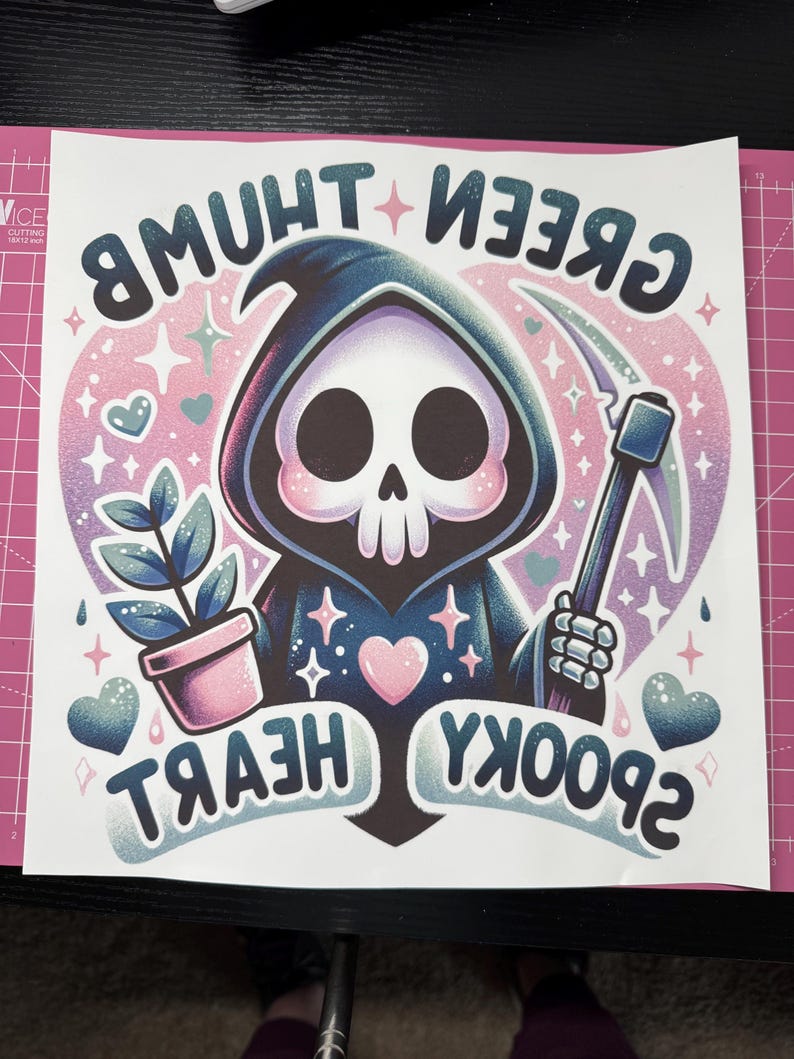 K&ouml;nnte beinhalten: Eine Cartoon-Illustration des Sensenmanns mit einem rosa Herzen, einer Pflanze in einem rosa Topf und dem Text "Green Thumb", "Spooky" und "Heart" in einem rosa und violetten Farbschema.