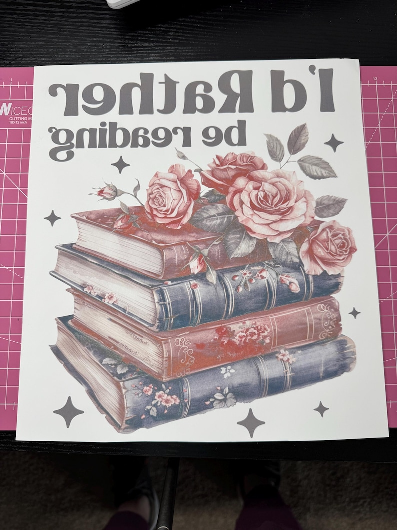 K&ouml;nnte beinhalten: Ein wei&szlig;er Hintergrund mit dem Text "I'd rather be reading" in Grau. Ein Stapel Vintage-B&uuml;cher mit Blumendesigns ist mit rosa Rosen und gr&uuml;nen Bl&auml;ttern verziert. Das Bild ist mit grauen Sternen akzentuiert.