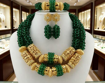 Peut inclure: Un ensemble de bijoux complet comprenant un collier, un bracelet et des boucles d'oreilles. Le collier est composé de plusieurs rangées de perles vertes avec des accents dorés en filigrane. Le bracelet et les boucles d'oreilles incorporent également des perles vertes et des éléments dorés.