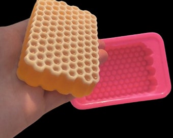 May include: A pink silicone mold with a honeycomb pattern, and a finished soap bar with a honeycomb pattern.