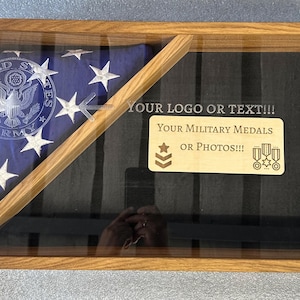Könnte beinhalten: Eine Holz-Schattenbox mit einer gefalteten amerikanischen Flagge und einem schwarzen Hintergrund. Die Flagge hat ein Siegel der US-Armee. Die Box hat eine Plakette mit der Aufschrift "YOUR LOGO OR TEXT!!! YOUR MILITARY MEDALS OR PHOTOS!!!"