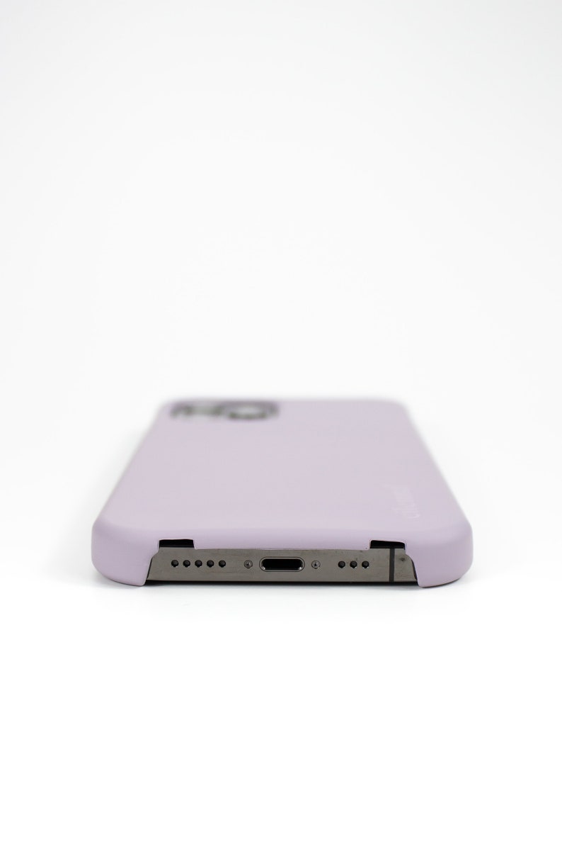 May include: A lavender phone case with a cutout for the camera lens and a charging port.