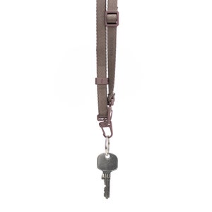 May include: A brown key lanyard with a silver key attached. The lanyard has a metal clip and a plastic buckle.
