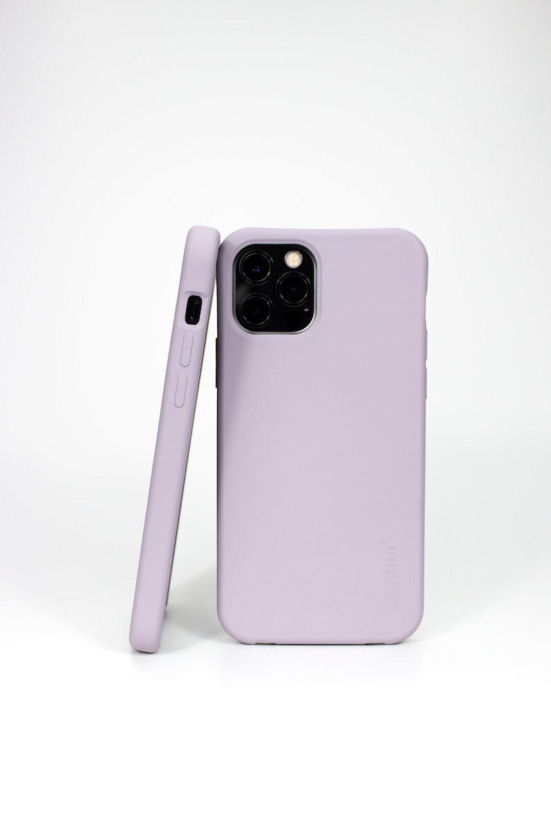 May include: Two lilac-colored phone cases, one is a standard case and the other is a slim case. The standard case has a camera cutout and the text "Nomad" printed on the back.