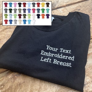 May include: Black t-shirt with white embroidery that says "Your Text Embroidered Left Breast".
