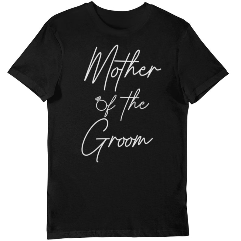 May include: Black t-shirt with the white cursive text "Mother of the Groom" and a diamond ring graphic. The shirt is a short-sleeved crew neck style, suitable for casual wear.