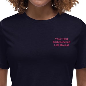 May include: A navy blue t-shirt with the text "Your Text Embroidered Left Breast" embroidered on the left side of the chest.