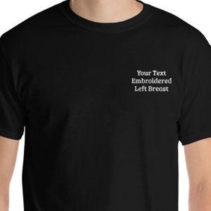 May include: Black t-shirt with the text "Your Text Embroidered Left Breast" on the left side of the chest.