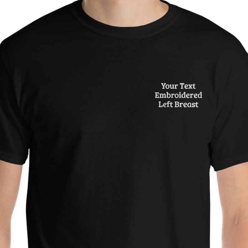 May include: Black t-shirt with the text "Your Text Embroidered Left Breast" on the left side of the chest.