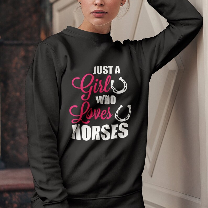 May include: Black sweatshirt with the text "Just a Girl Who Loves Horses" in pink and white lettering with two white horseshoes.