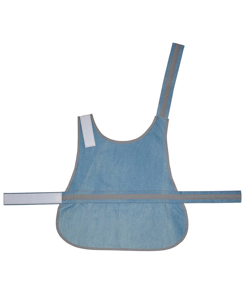 May include: A light blue denim dog vest with reflective gray trim and a white strap. The vest has a single strap that goes over the dog's head and a buckle closure around the chest.