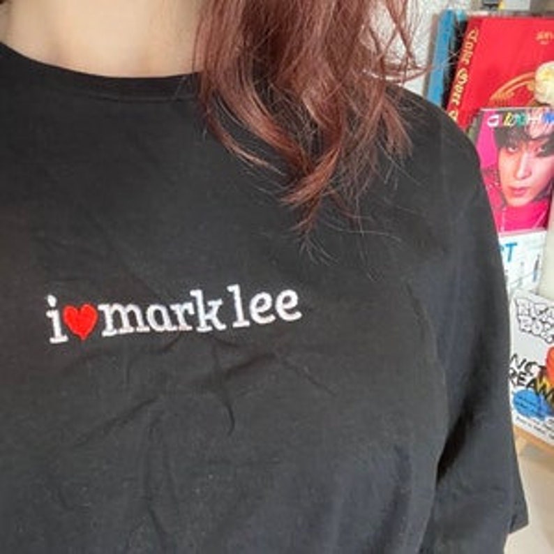May include: Black t-shirt with a white embroidered design that says "i &hearts; marklee" with a red heart.