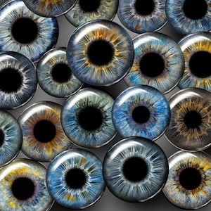 Può includere: Una collezione di 18 oggetti di colore blu, marrone e oro a forma di occhio con pupille nere. Gli oggetti sono disposti in un gruppo su uno sfondo grigio.