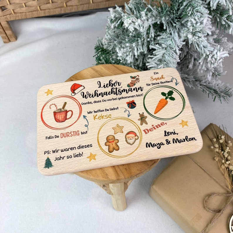 May include: A wooden Christmas sign with a Santa Claus, gingerbread man, and a mug of hot chocolate. The sign says "Lieber Weihnachtsmann" and "Danke, dass Du vorbei gekommen bist!"  It also says "Falls Du durstig bist" and "PS: Wir waren dieses Jahr so lieb!"