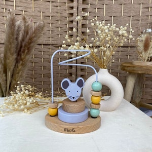 May include: A wooden toy with a mouse face and a wire maze. The toy has a stack of colorful beads and a base with the word "Marli" on it.
