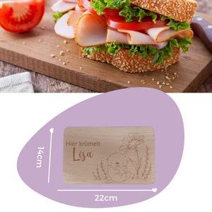 May include: A wooden cutting board with a cute otter design and the text "Hier kr&uuml;melt Lisa". The board measures 22 cm by 14 cm.
