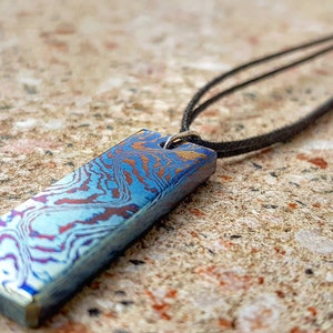 Beautiful handmade Timascus pendant with a Sterling Silver eyelet and a leather band.