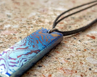 Beautiful handmade Timascus pendant with a Sterling Silver eyelet and a leather band.