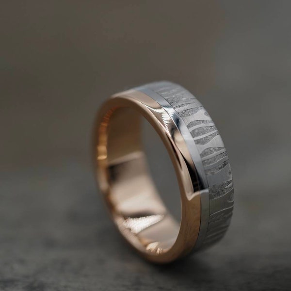 Stunning Damascus Steel ring with Stainless Steel and a Gold rail lined in Gold. Customizable and hypoallergenic.