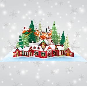 May include: A 3D pop-up Christmas card featuring a winter village scene with Santa Claus flying over a snowy town with reindeer. The card is decorated with red and green houses, trees, and snow.