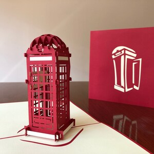 May include: A red 3D pop-up card featuring a detailed model of a classic British red telephone booth. The card is closed, showing a simple silhouette of the telephone booth on the front.