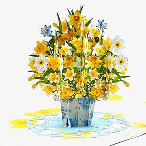 A vibrant 3D pop-up card displaying a bouquet of yellow and white daffodils in a floral-patterned pot. Perfect for special occasions to brighten someone's day