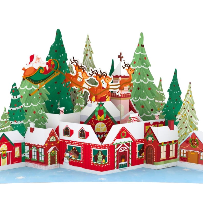 May include: A 3D pop-up Christmas card featuring a snowy village with red houses, green trees, and Santa Claus flying in a sleigh pulled by reindeer.