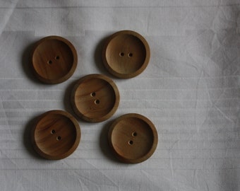 May include: Five wooden buttons with two holes each. The buttons are brown and have a smooth, rounded surface.