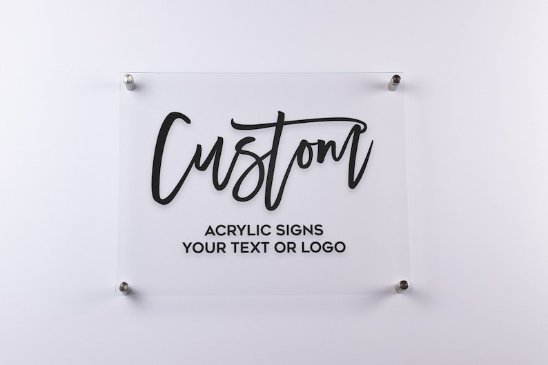 May include: A clear acrylic sign with black text that reads "Custom" and "Acrylic Signs Your Text or Logo".