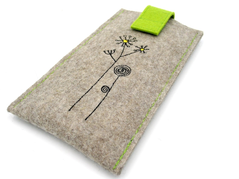 May include: A gray felt phone case with a green felt flap closure. The case has a simple embroidered design of a flower with a yellow center.