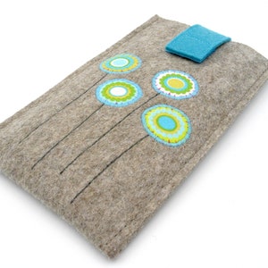 May include: A gray felt phone case with a blue leather flap closure. The case is decorated with colorful embroidered flowers.