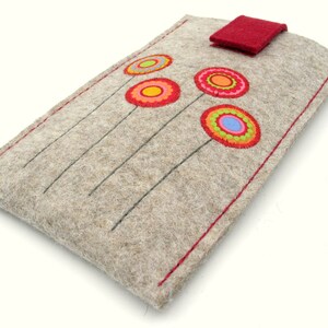 May include: A gray felt phone case with a red flap closure and colorful embroidered flowers. The flowers are red, orange, yellow, green, and blue.