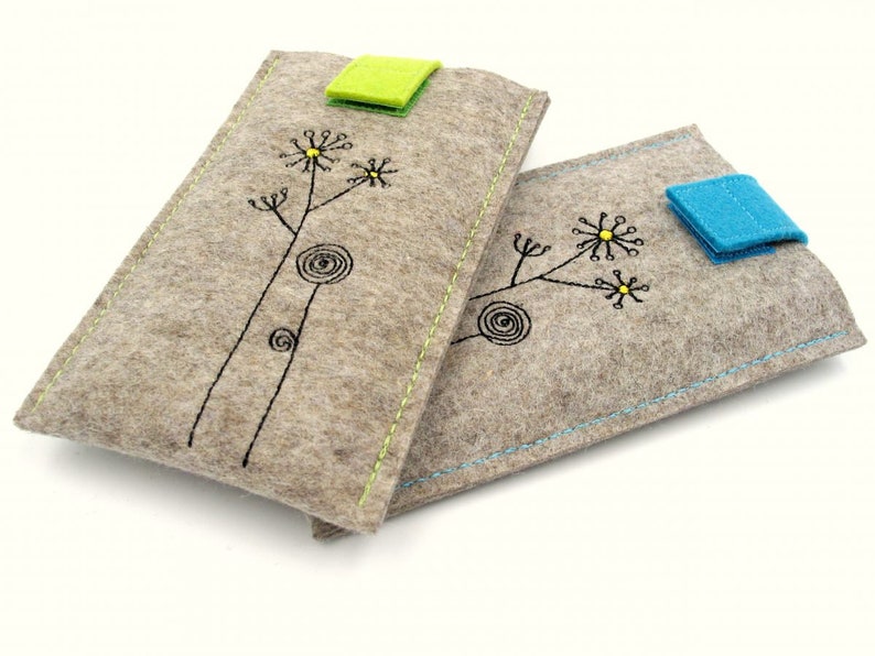 May include: Two gray felt phone cases with black embroidered flower designs. One case has a green felt flap closure and the other has a blue felt flap closure.