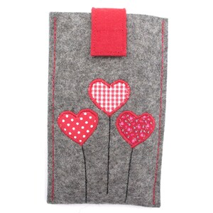 May include: Grey felt phone case with three red felt hearts. The hearts are decorated with white polka dots, red and white gingham, and a pink floral pattern.