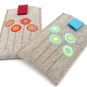 May include: Two gray felt phone cases with colorful embroidered flowers. One case has red flowers and a red flap closure. The other case has blue flowers and a blue flap closure.