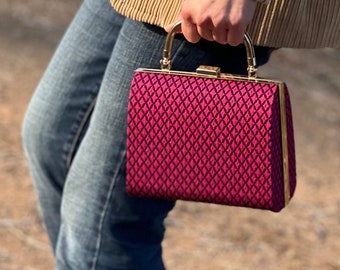 Black/pink patterned clutch with gold frame and shoulder chain