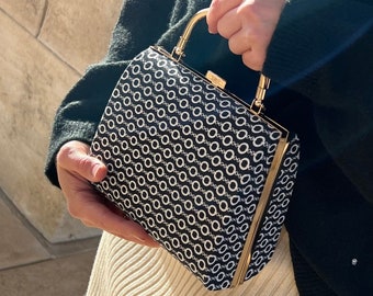 Black/white patterned clutch with gold frame and shoulder chain