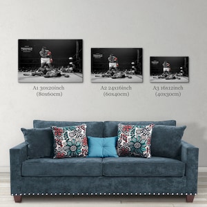 May include: Three black and white framed prints of a boxer in action. The prints are in different sizes, with the largest print being 30 inches by 20 inches, the middle print being 24 inches by 16 inches, and the smallest print being 16 inches by 12 inches. The prints are hanging on a white wall above a blue sofa.