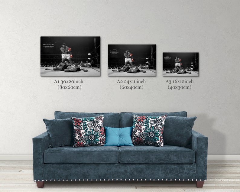 May include: Three black and white framed prints of a boxer in action. The prints are in different sizes, with the largest print being 30 inches by 20 inches, the middle print being 24 inches by 16 inches, and the smallest print being 16 inches by 12 inches. The prints are hanging on a white wall above a blue sofa.