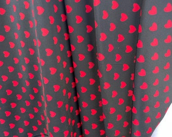 May include: Black fabric with a repeating pattern of red hearts.