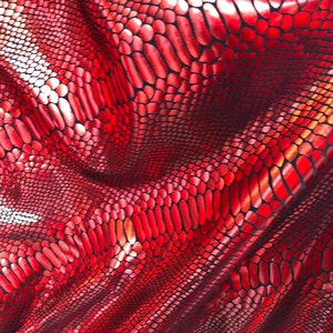 Puede incluir: Tela roja iridiscente con un patr&oacute;n de piel de serpiente.