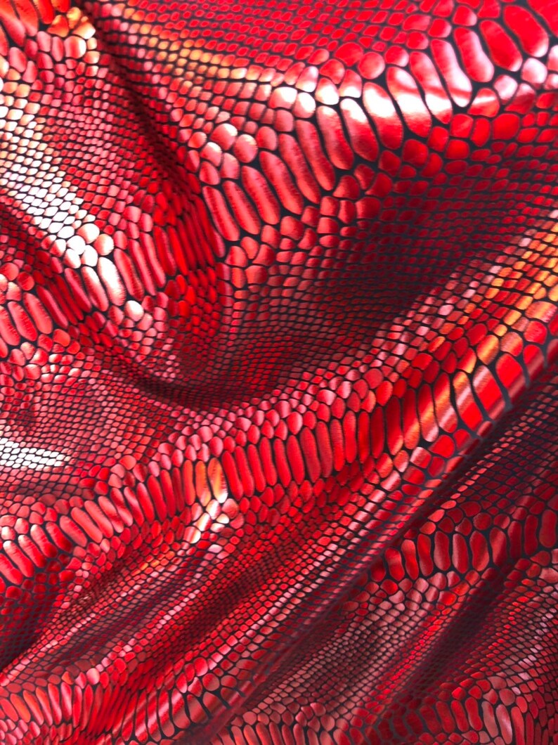 Puede incluir: Tela roja iridiscente con un patr&oacute;n de piel de serpiente.