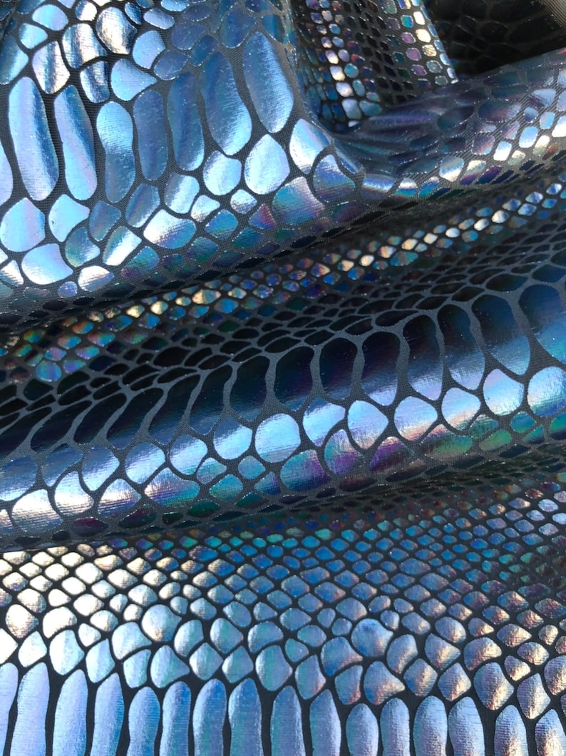 Puede incluir: Primer plano de una tela azul y negra iridiscente con un patr&oacute;n de piel de serpiente.