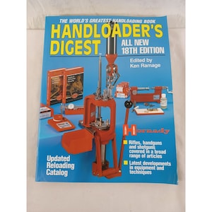 Puede incluir: Un libro rojo y azul titulado "Handloader's Digest" con las palabras "All New 18th Edition" y "Edited by Ken Ramage". La portada del libro presenta una prensa de recarga roja y otros equipos de recarga.
