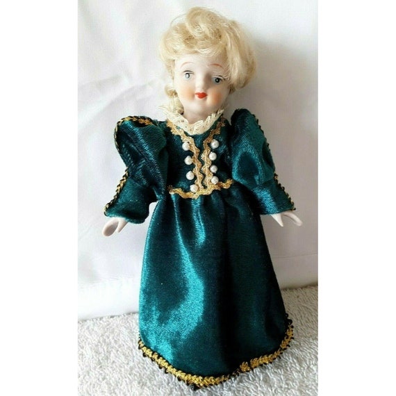 porcelain doll green velvet dress Vintage Sitting Blonde Hair This Charming Doll Features A Luxurious Velvet Outfit In Deep Green With Elegant White Lace Accents Porcelain Doll-Green Velvet Dress with