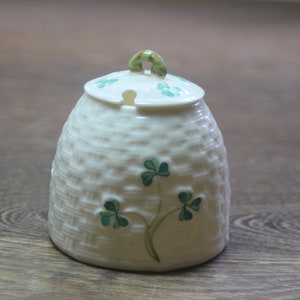 Peut inclure: Sucrier en céramique blanche avec un motif de trèfle vert et un motif tissé. Le couvercle a une poignée en trèfle vert.