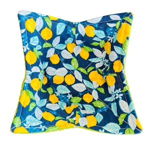 May include: A green and blue quilted bowl liner with a lemon print. The bowl liner is made of fabric and has a square shape.