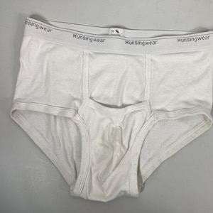May include: White briefs with the brand name "Munsingwear" printed on the waistband. The briefs are made of a soft material and feature a classic design. The size tag reads 36.