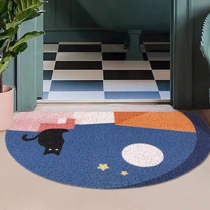 May include: A blue, orange, and pink half-circle doormat with a black cat, a white moon, and yellow stars.