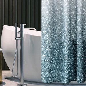 Può includere: Tenda da doccia a fantasia blu e bianca con un motivo floreale. La tenda è davanti a una vasca da bagno bianca e un rubinetto cromato. Lo sfondo comprende una parete scura e un tavolino.